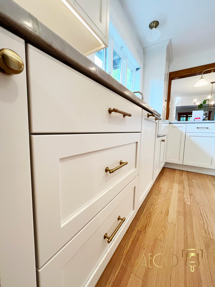 a kitchen with white cabinets and a wooden floor