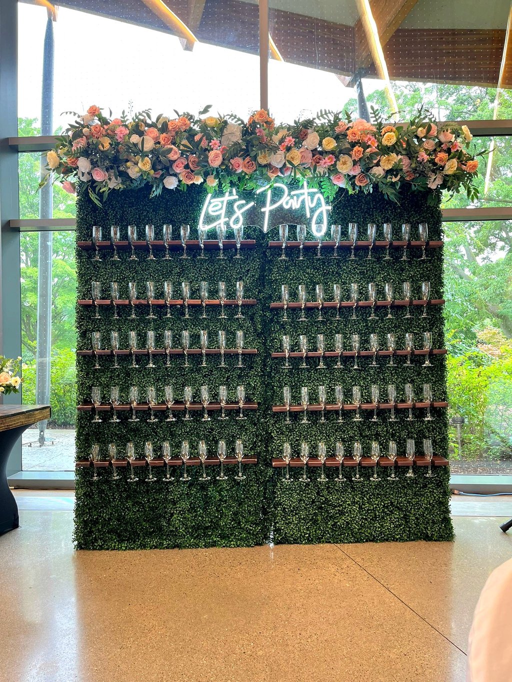 a wall of wine glasses with a green champagne wall wall
