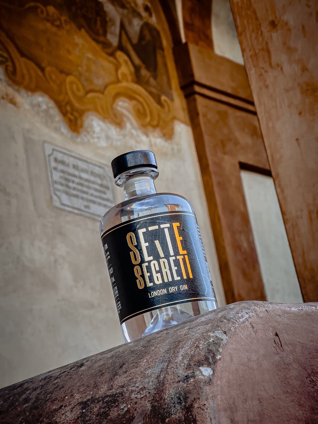a bottle of beer sitting on top of a stone wall