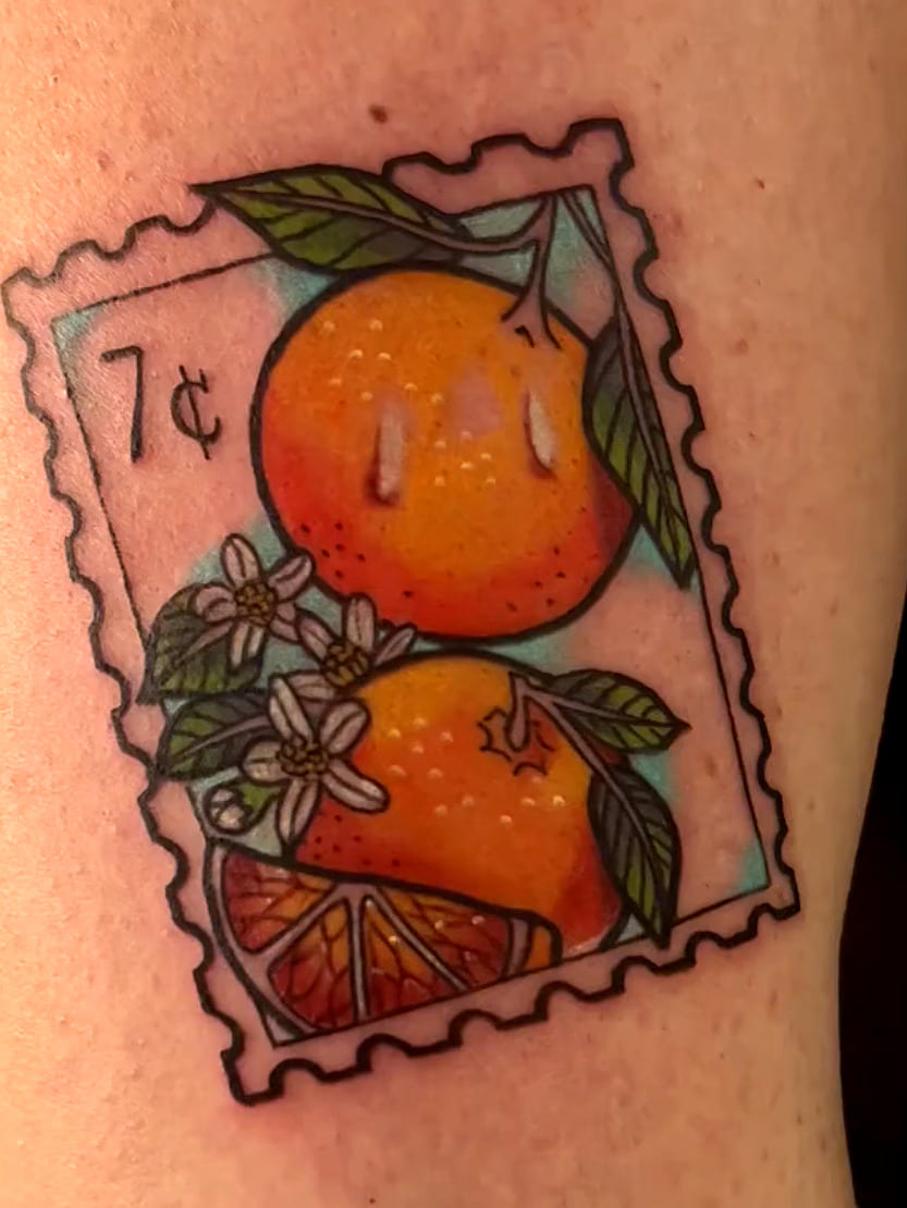 Vintage postage stamp tattoo featuring oranges, citrus blossoms, and a 7 cent mark.