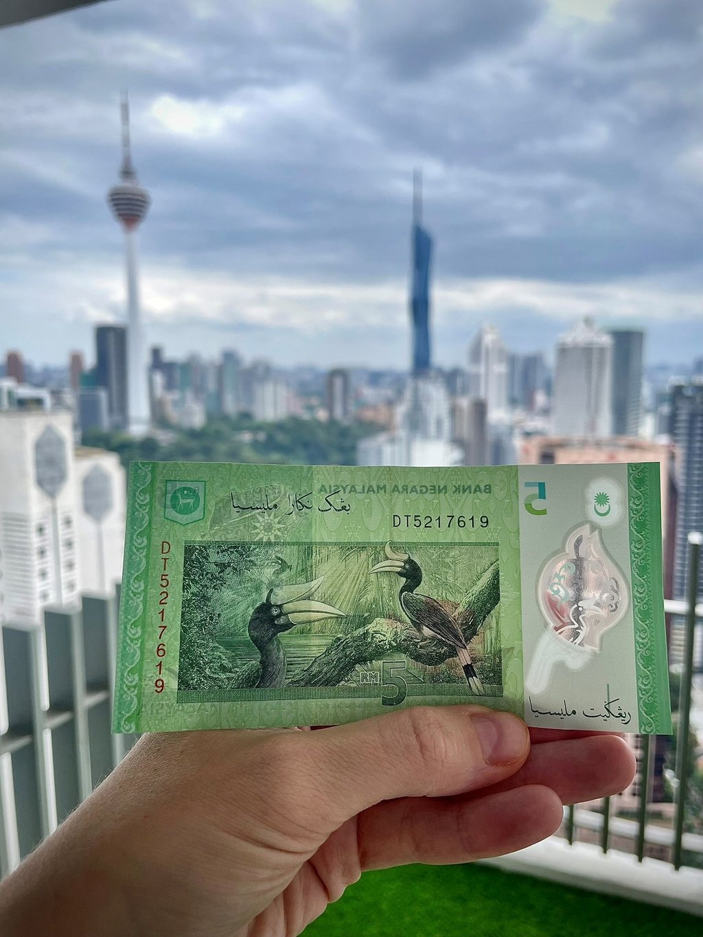 malajskie pieniądze na tle Kuala Lumpur