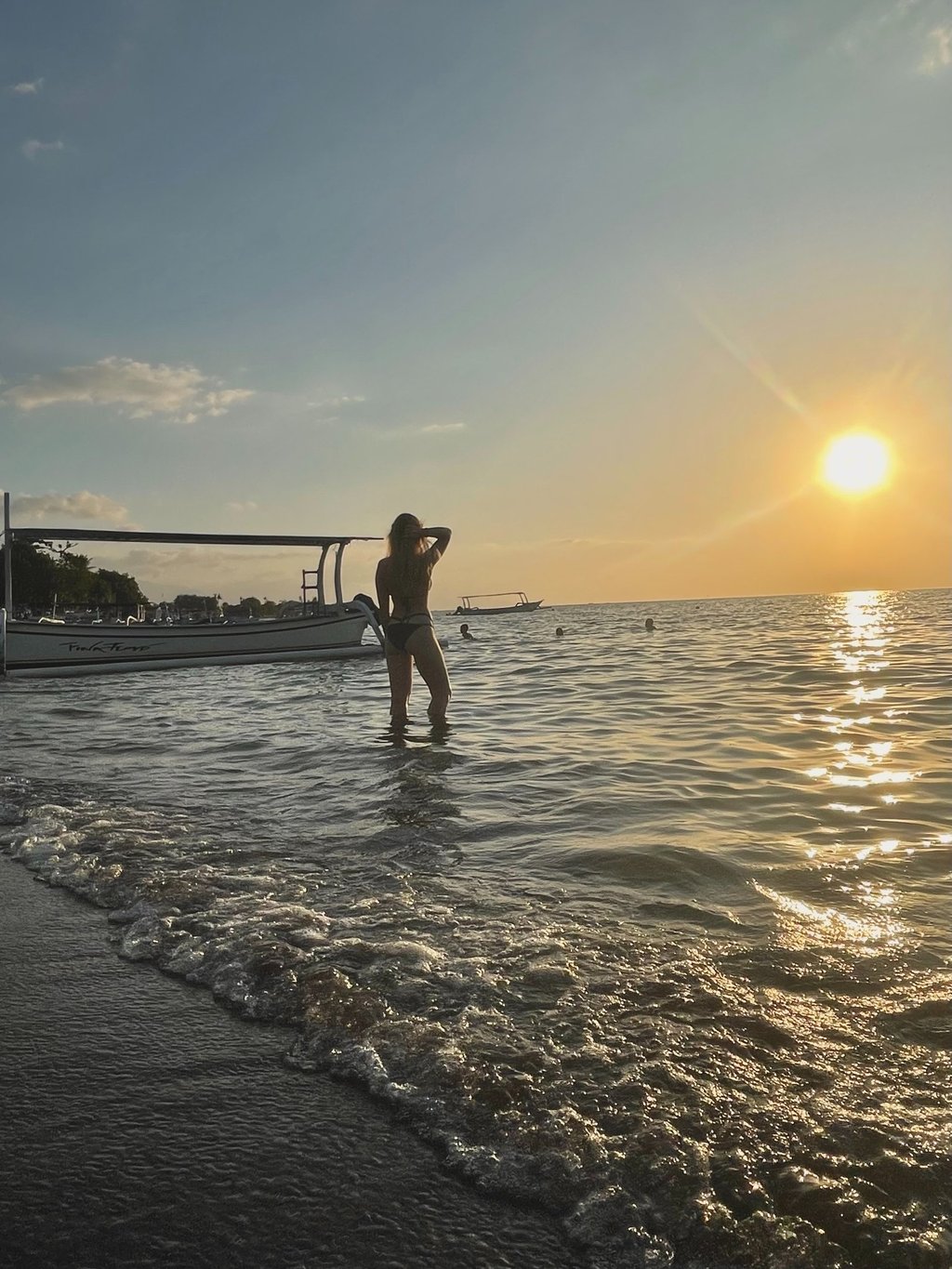 kobieta w morzu o zachodzie słońca