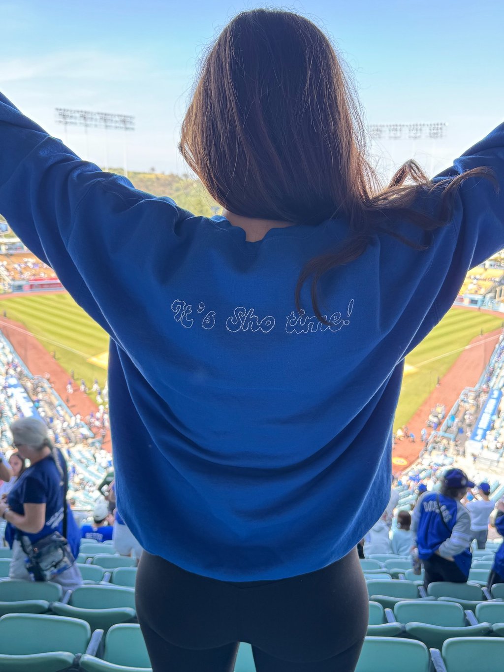 back of a sweatshirt on a girl at a baseball stadium