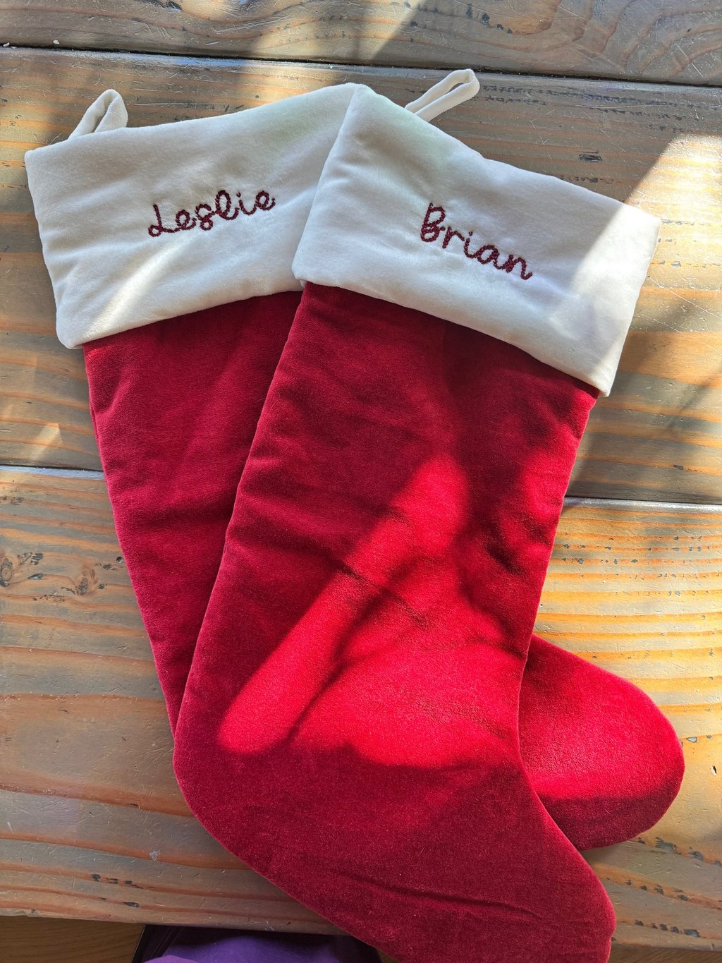 two red stockings with names embroidered on them