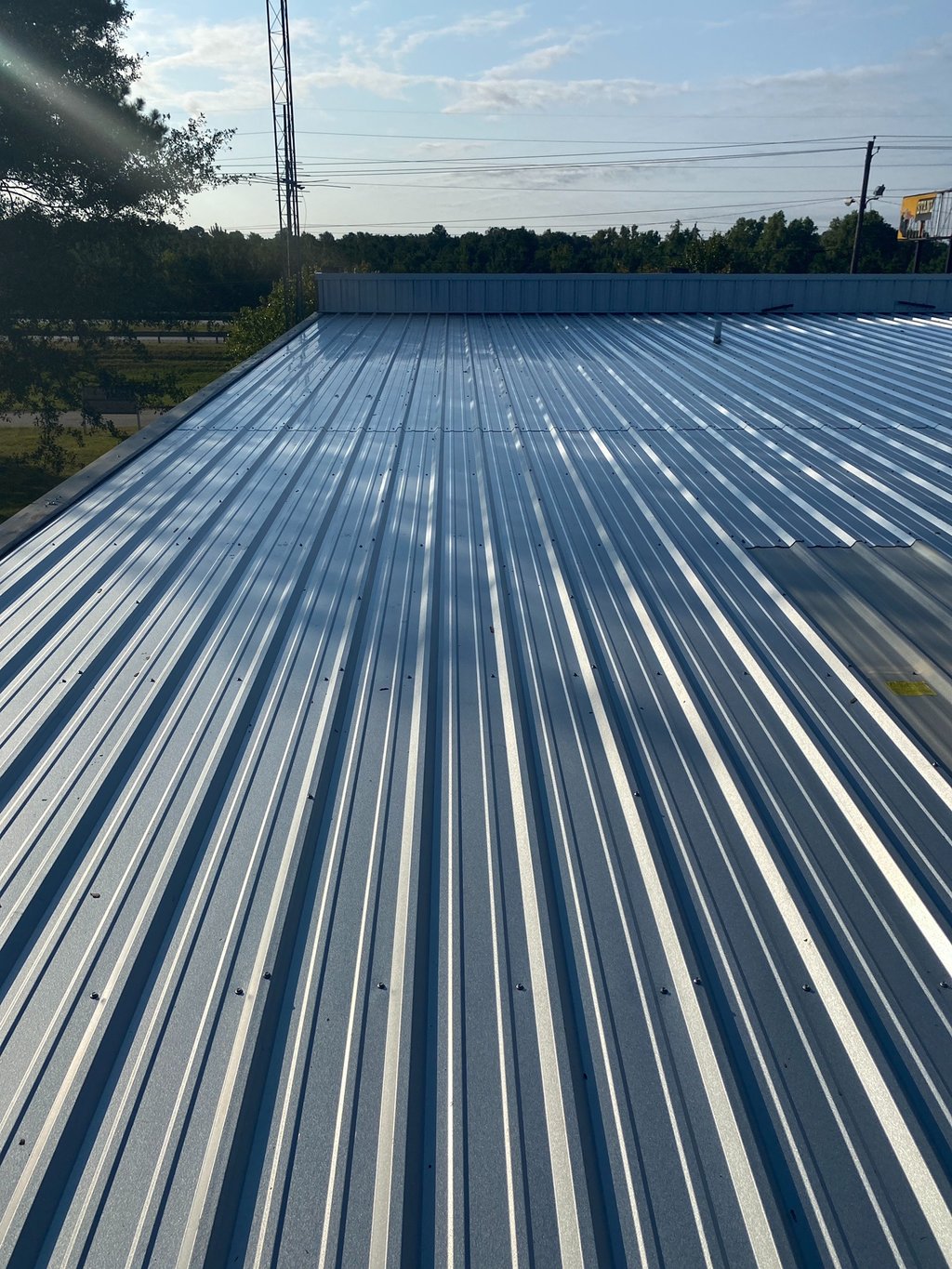 a metal roof with a blue sky and trees