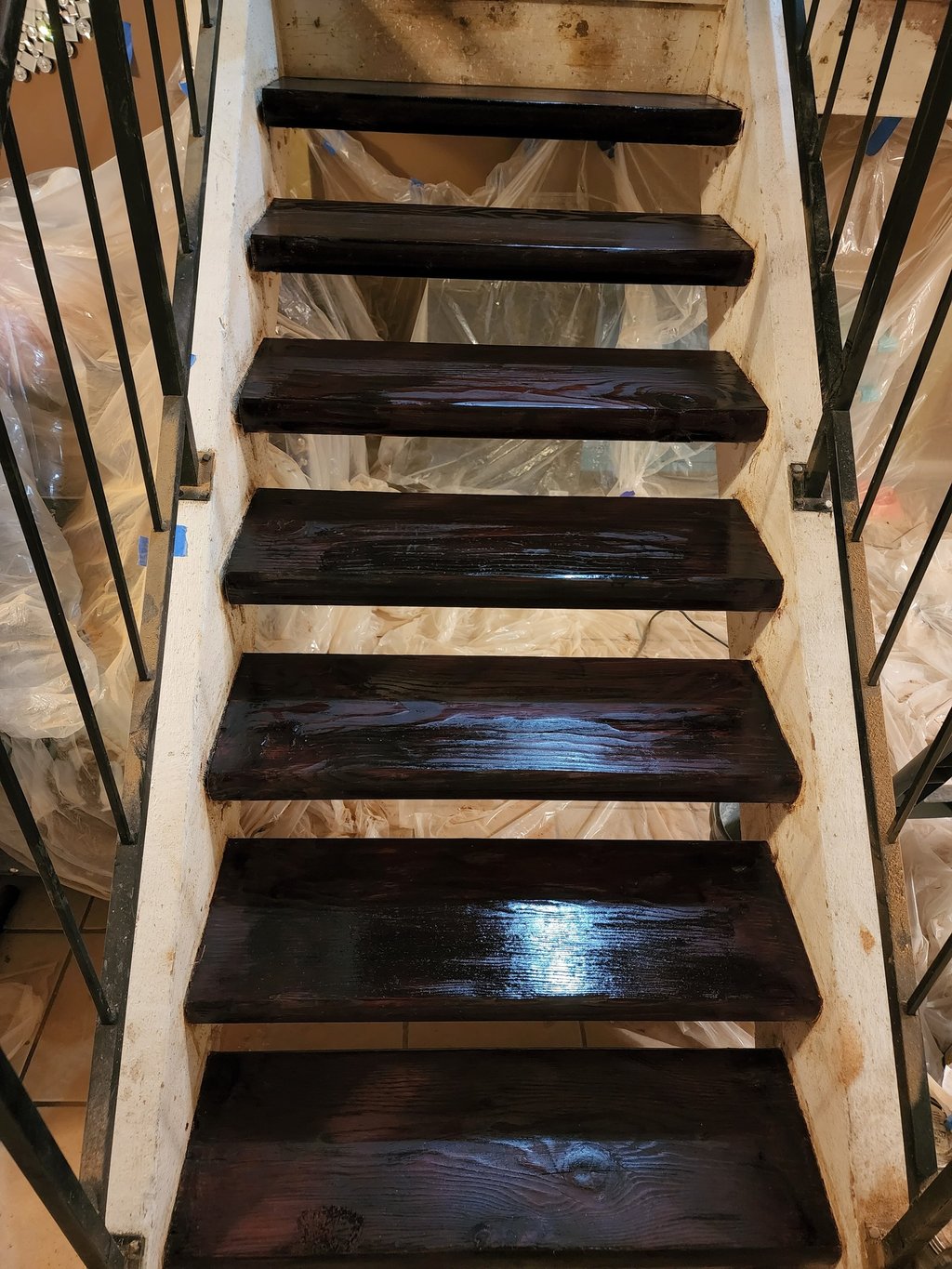 a staircase cased in a plastic bag stained wood stairs