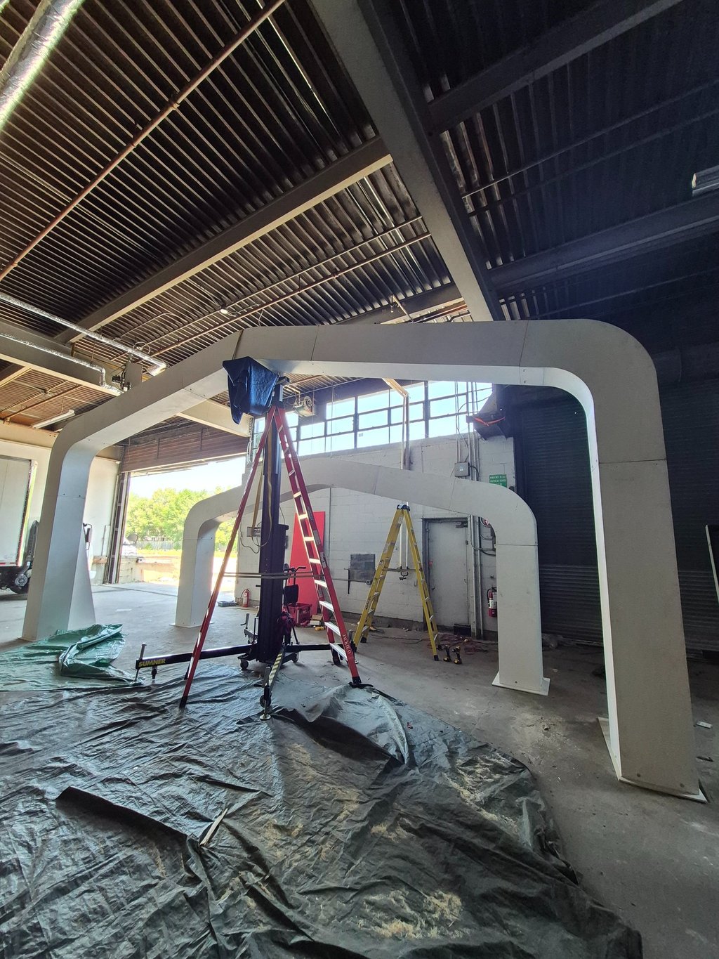 Large arched installation constructed in a warehouse space.