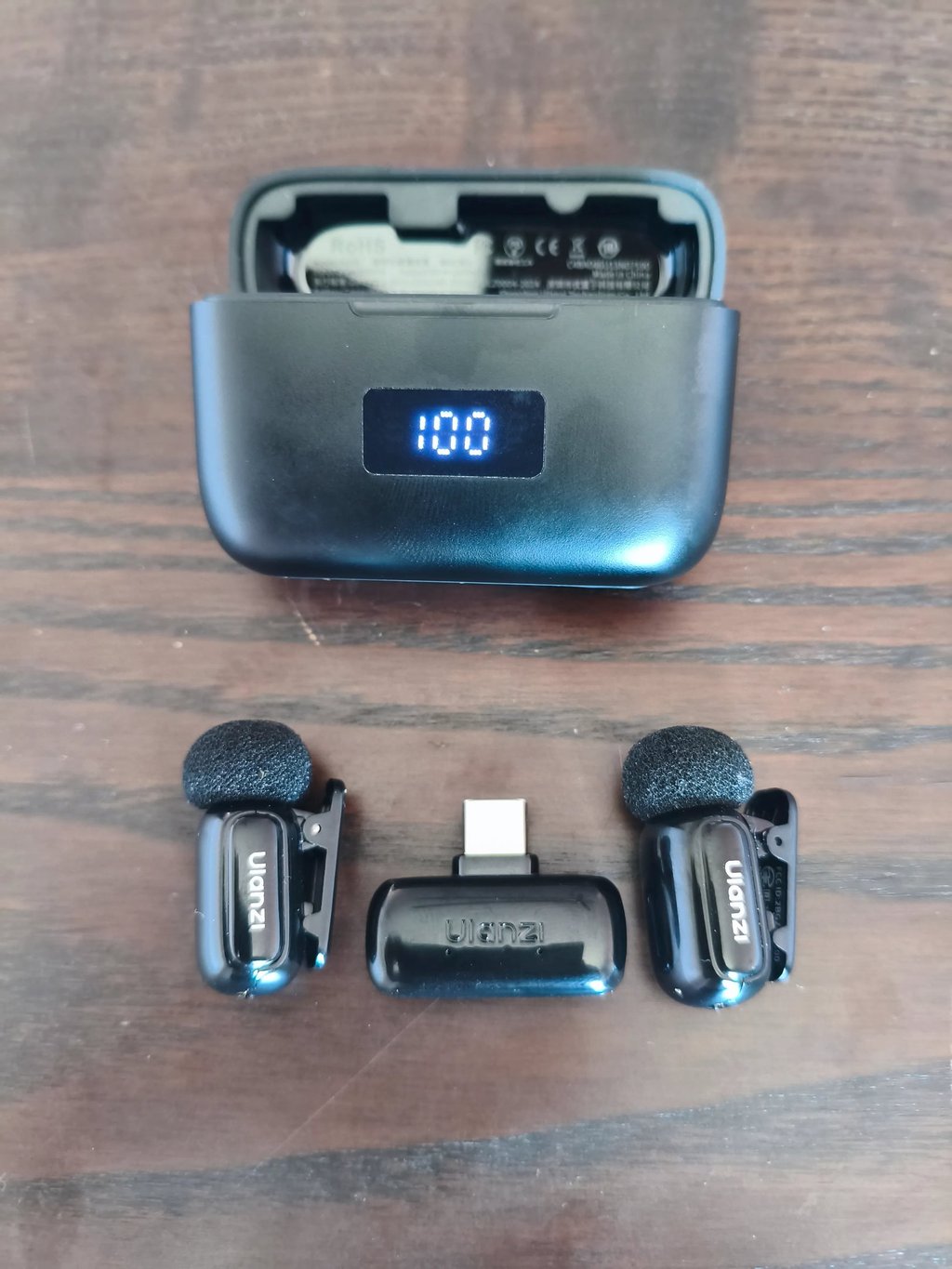 Ulanzi Micro A200 com caixa de carregamento aberta a mostrar bateria a 100% e dois microfones de lap