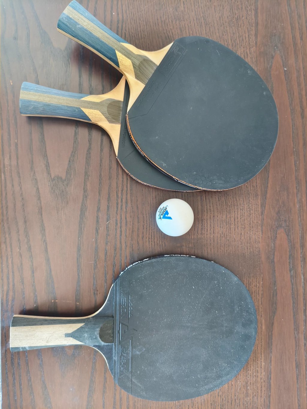 Review de raquetes de ping-pong JOOLA Carbon com revestimento preto e bola branca.