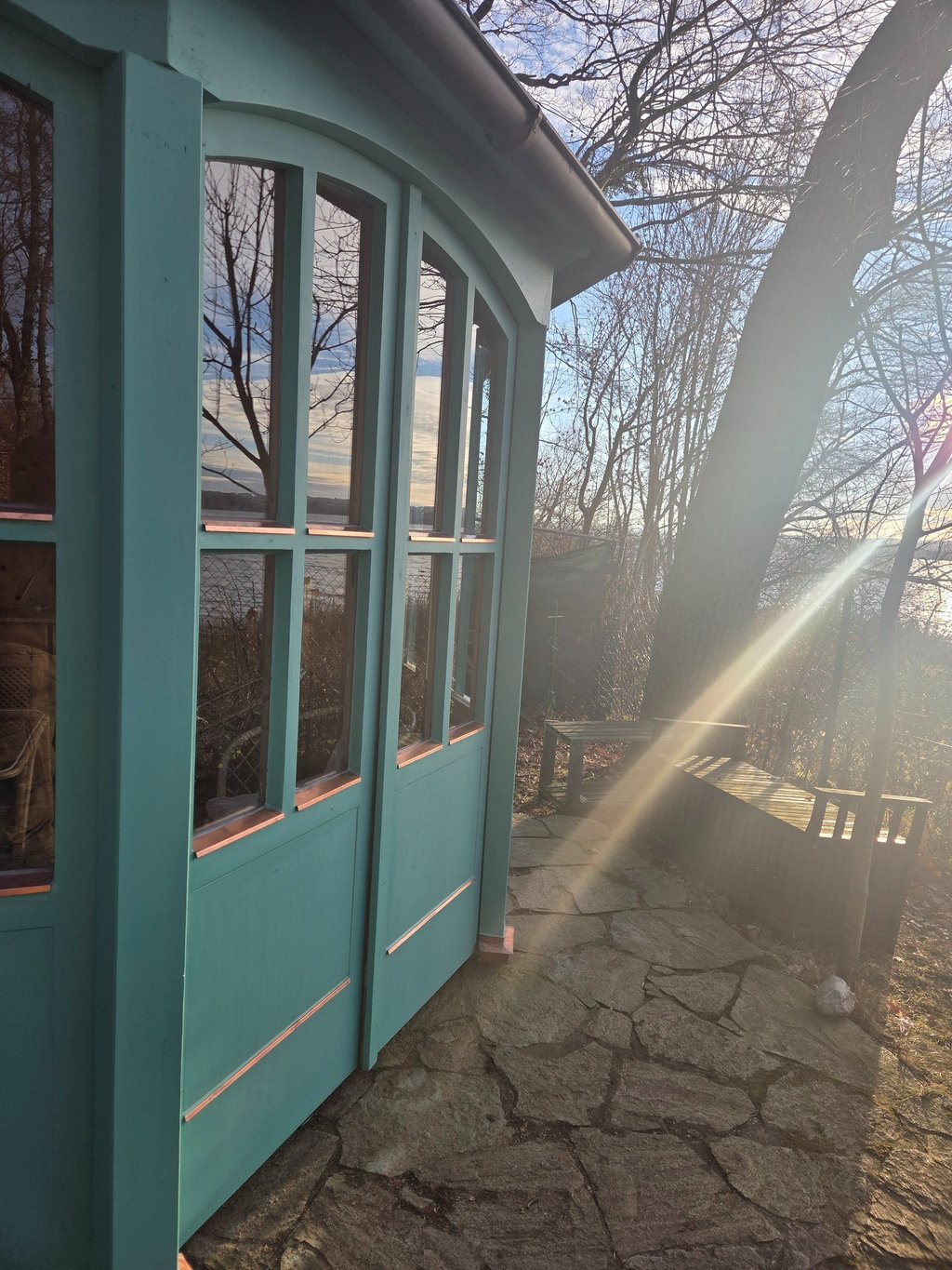 Grüner Holzpavillon mit verglasten Flügeltüren und Kupferdetails am Ufer des Ammersees von Holztechnik Volk