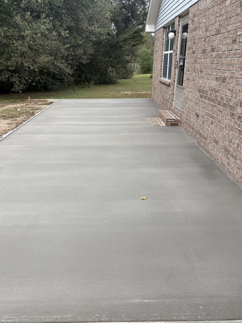 Side yard concrete walkway installation in Navarre FL with smooth surface