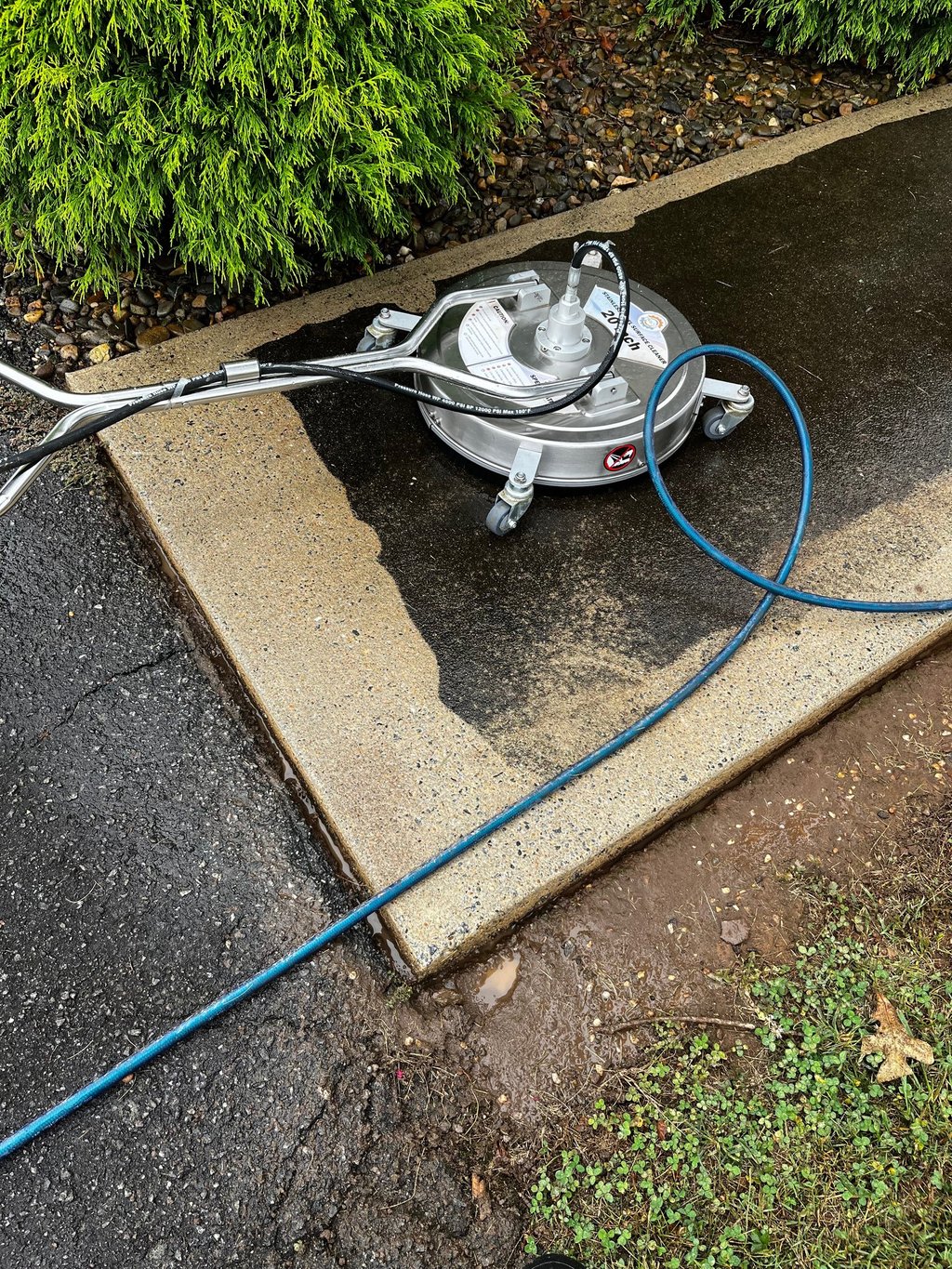 Pressure washing surface cleaner in action on dirty concrete driveway, Lenoir NC