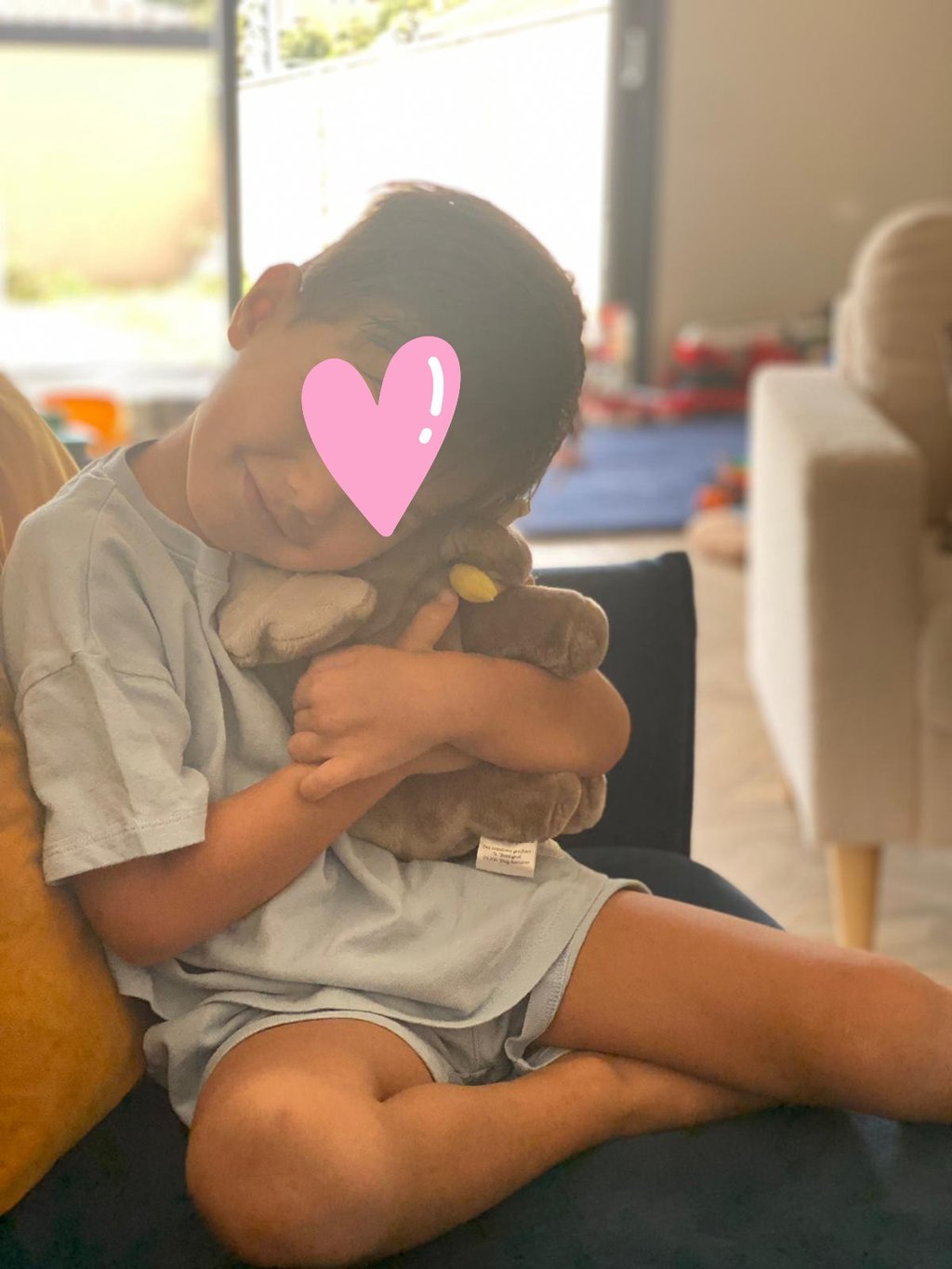 Enfant serrant contre lui une peluche artisanale cousue main, illustration du réconfort, de l’attach