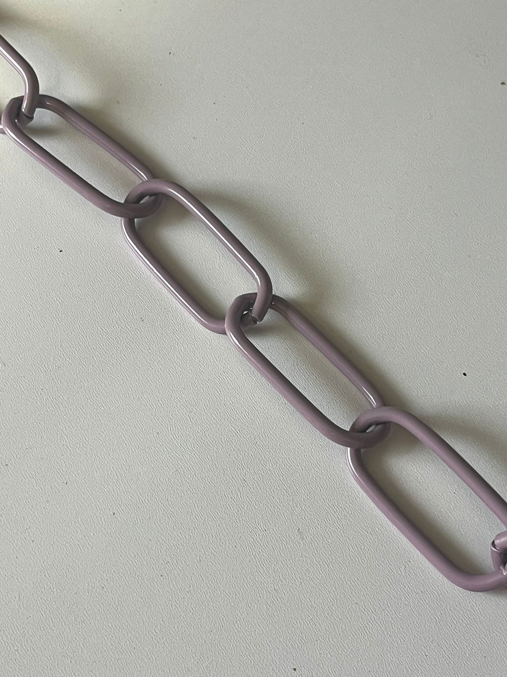 Runder Kreis mit einem Farbmuster mittig eine Kette in Lila, Hundekette, Pulverbeschichtet