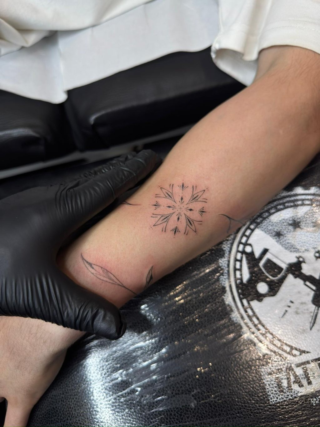 Fine line geometric star mandala tattoo on forearm – Sinkply Zürich