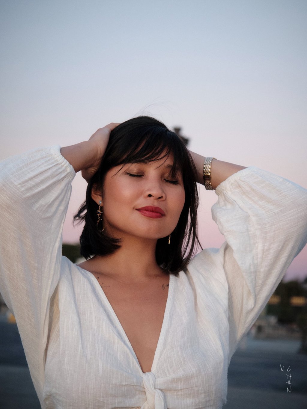 Modèle femme brune avec une chemise blanche sur un fond de ciel le soir