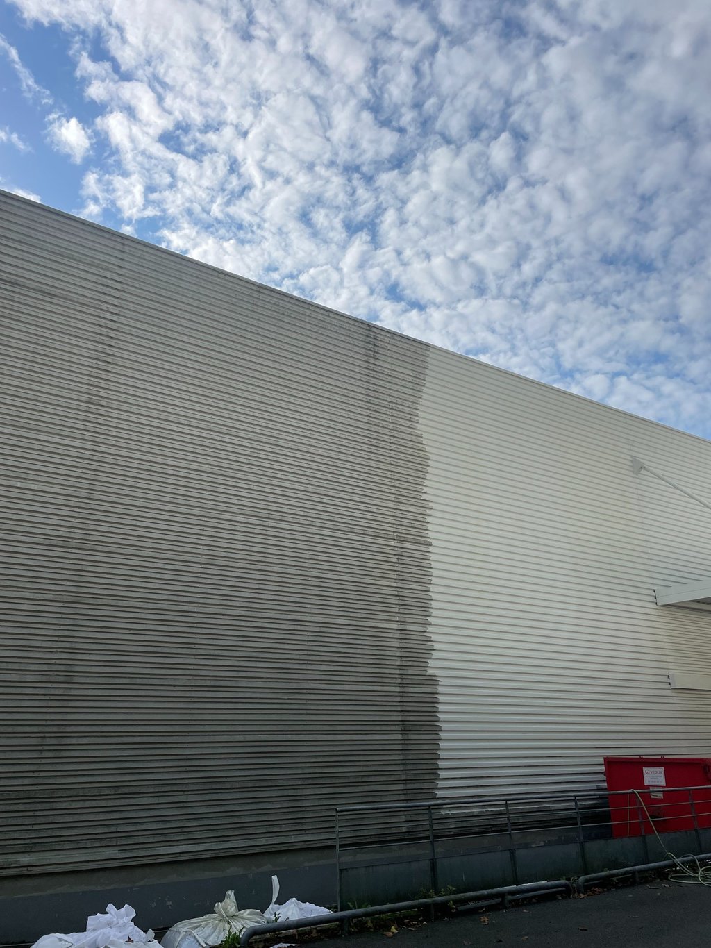 Résultat partiel de nettoyage de bardage, comparaison visible entre propre et encrassé