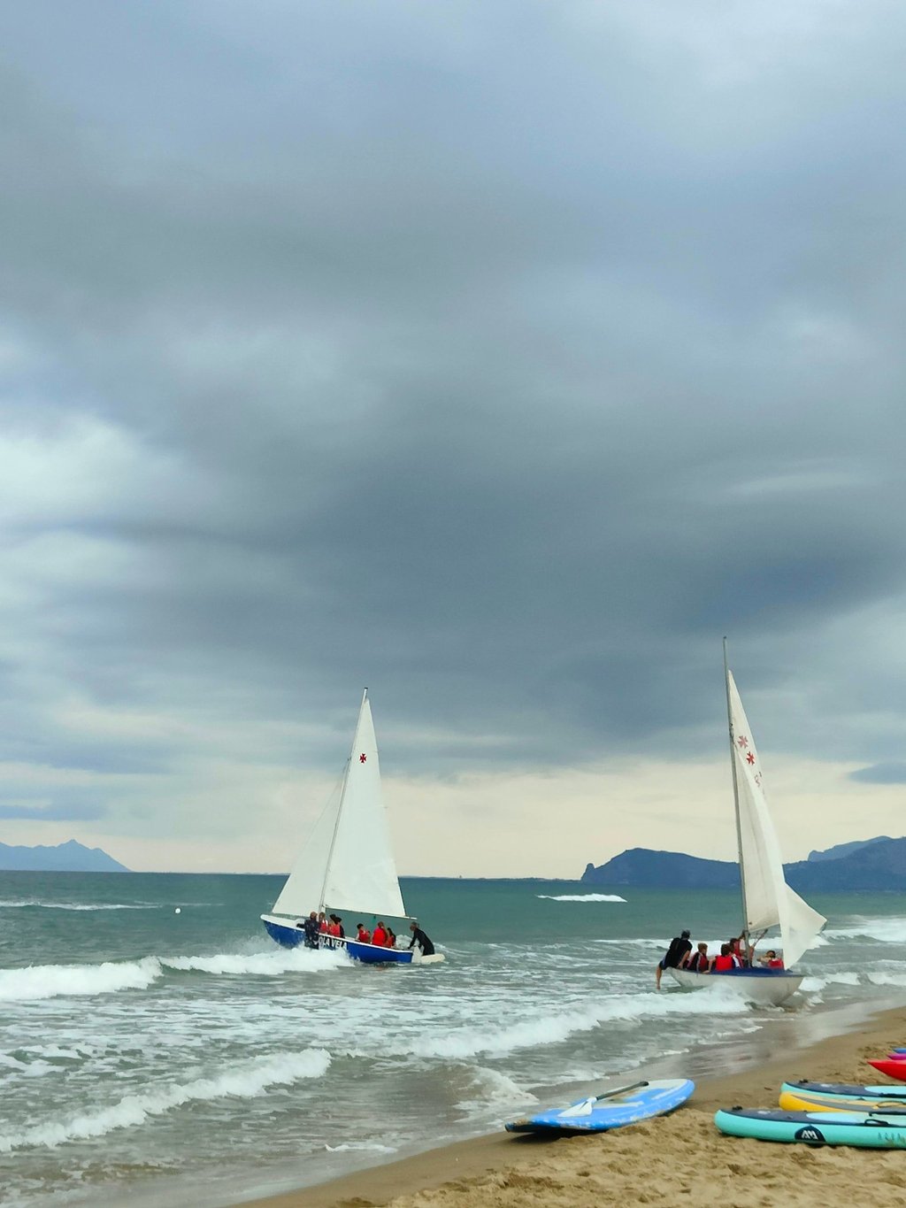 a group of people on a beach with surfboards