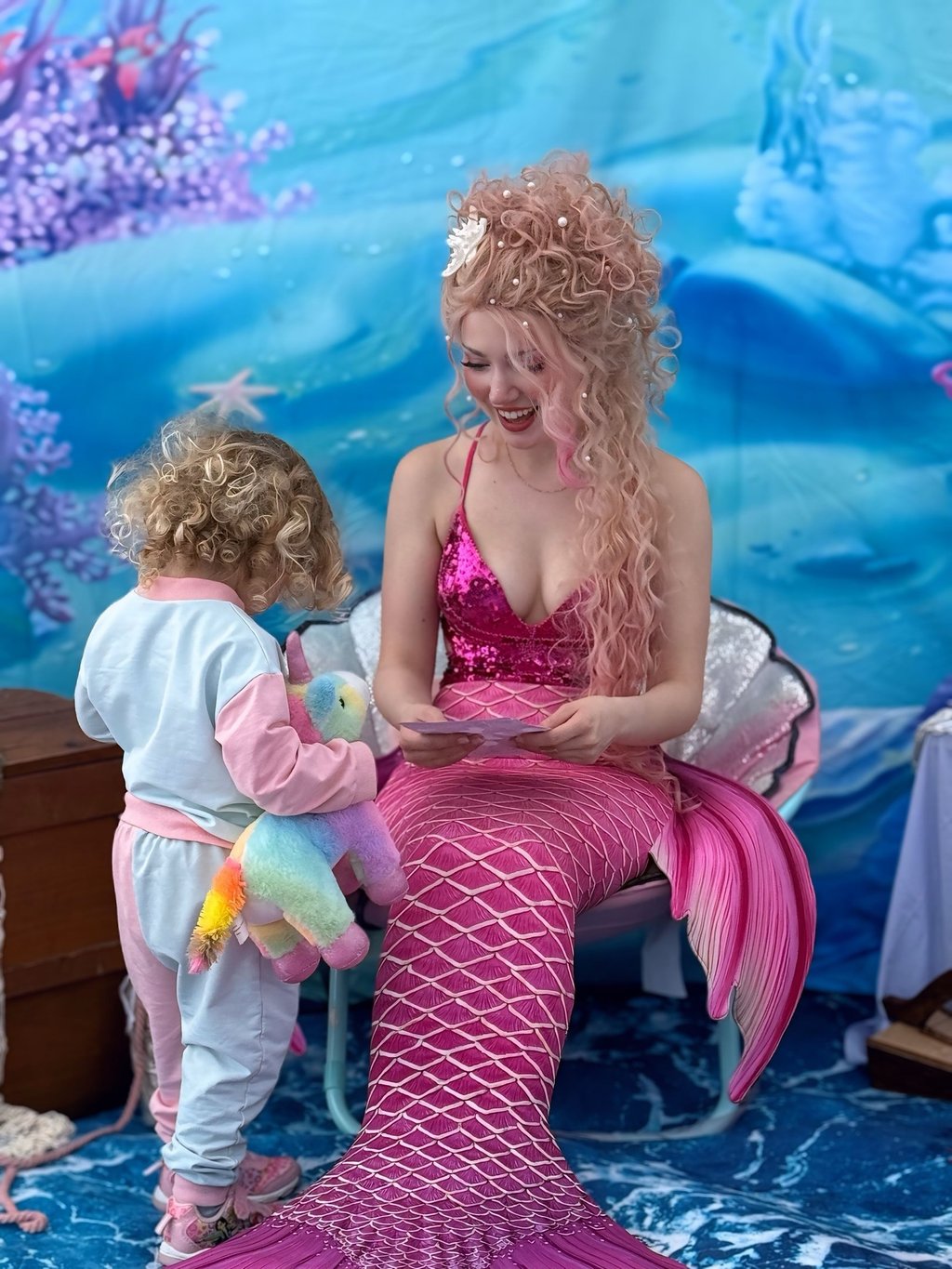 Pink mermaid shares a smile with a kid