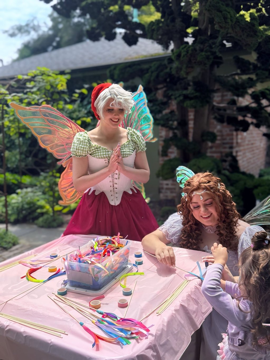 Strawberry and Purple Fairy do a craft with. a child