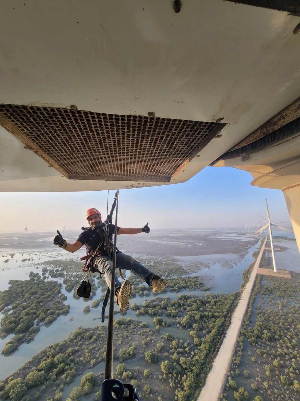 a man is hanging from a helicopter while he is hanging from a rope