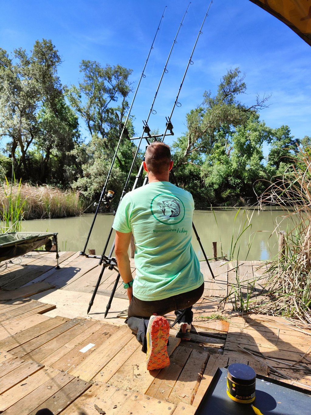 a man is fishing on a dock with a fishing rod