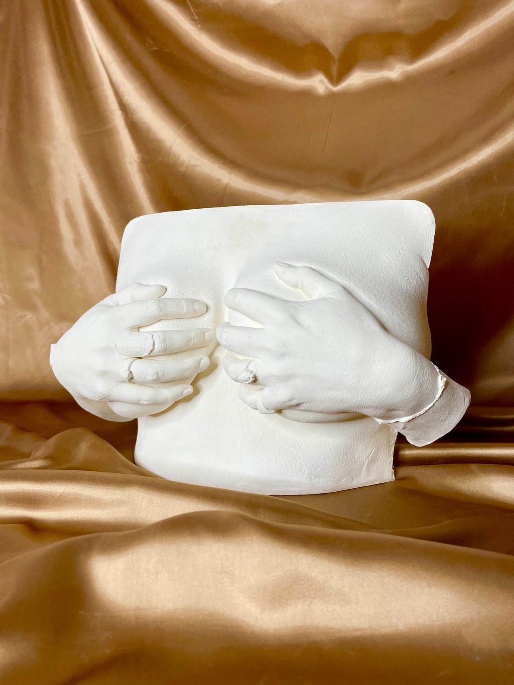 Moulage poitrine et mains en plâtre sur fond doré