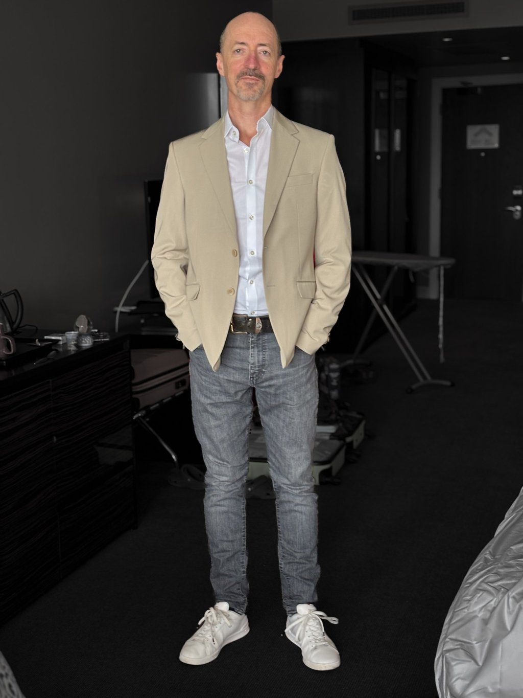 Portrait photo of Mark Murfitt wearing a cream colored jacked, white shirt, black jeans