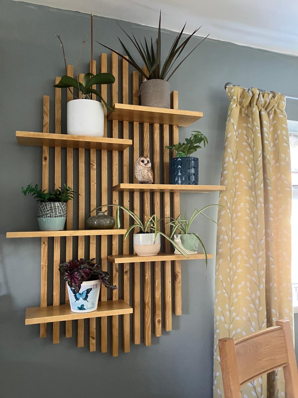 a wooden wall art shelf with plants