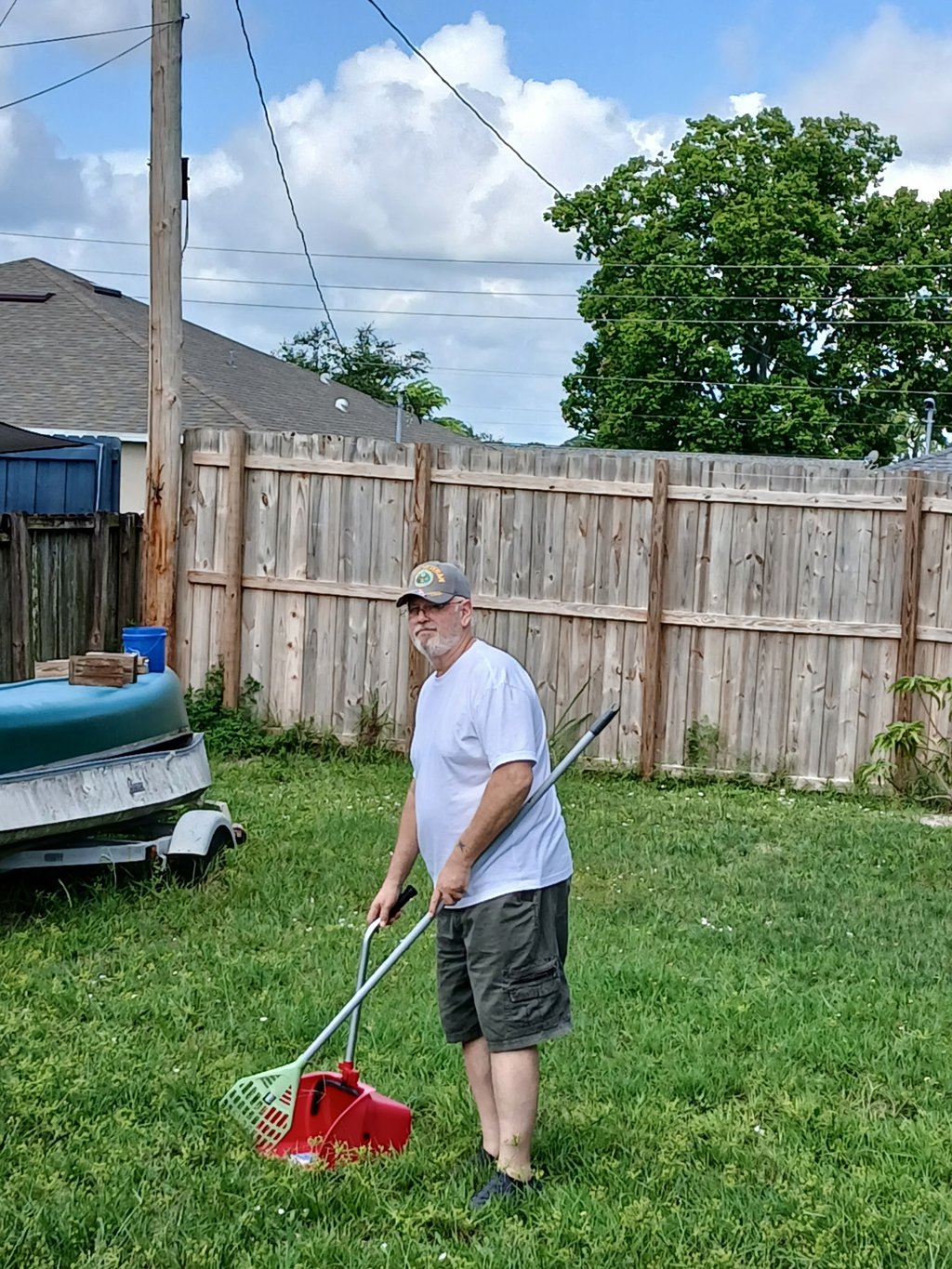 Robert using a sanitized scooper to remove waste from a customers back yard