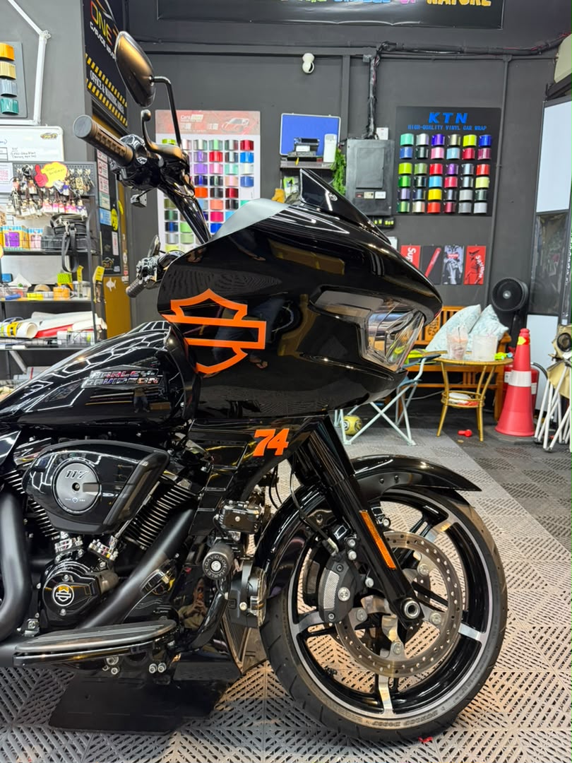 Harley-Davidson motorcycle with custom black and orange logo wrap