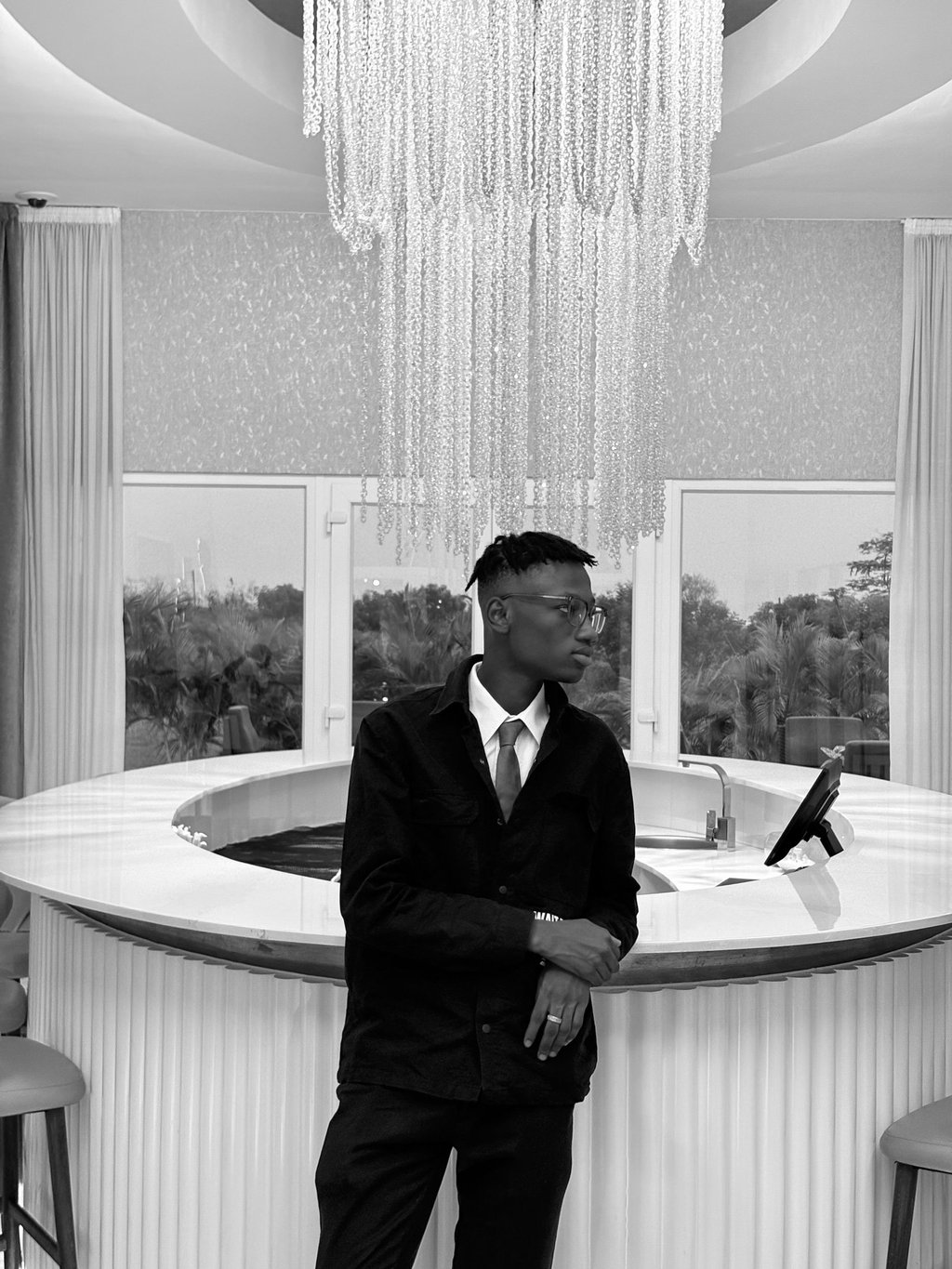 reed in a suit and tie standing in front of a bar