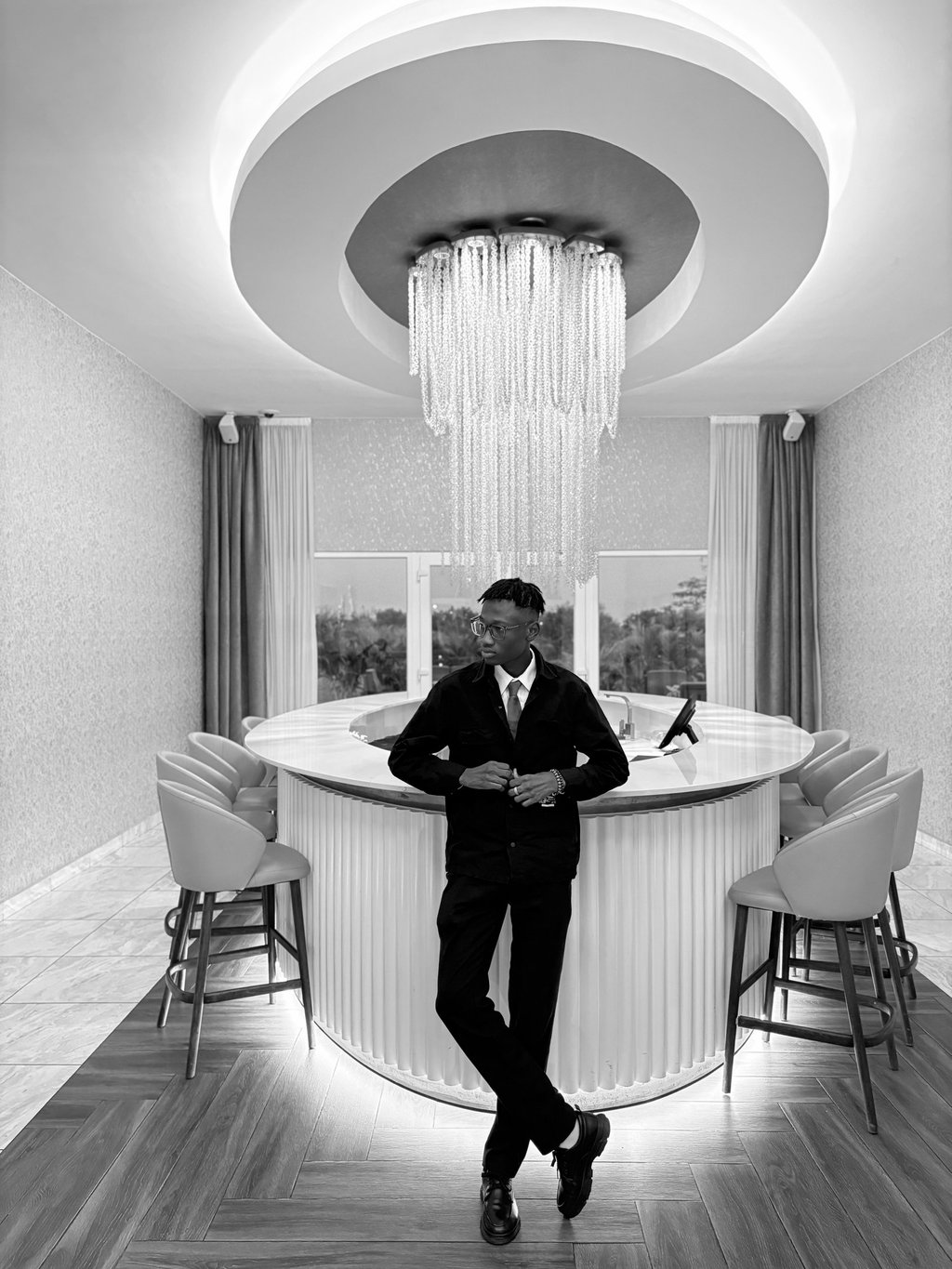 reed in a suit and tie standing infront of a bar