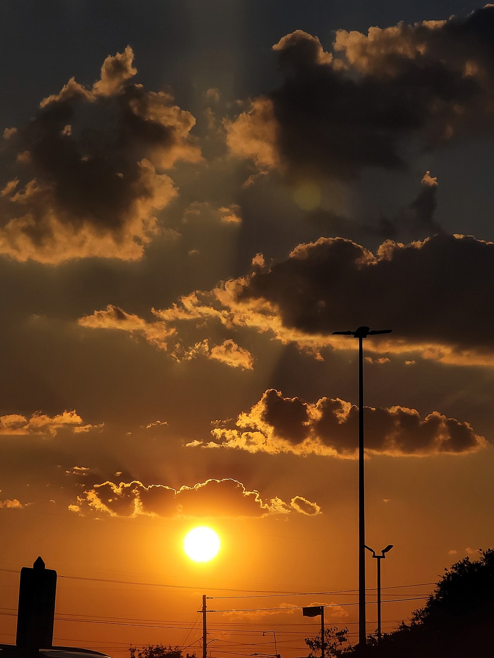 Yellow glowing sunrise with rays of sunlight shining through the clouds
