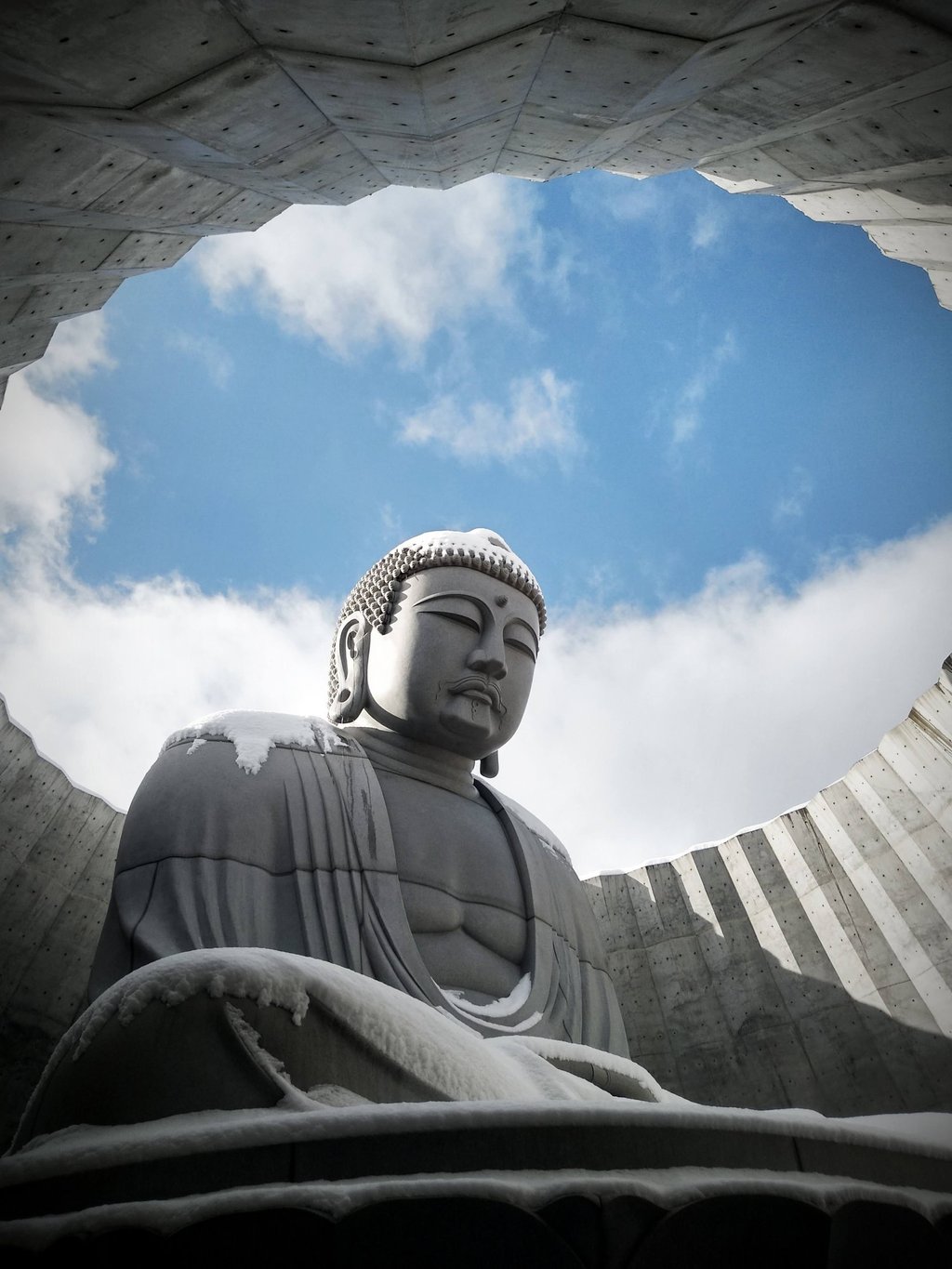 a concrete buddha statue sitting in a circular hole