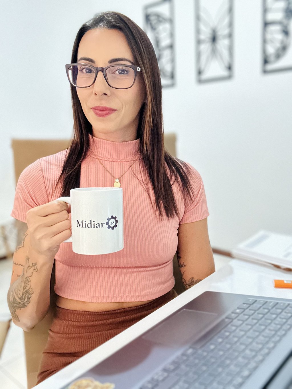 paula-sentada-a-mesa-olhando-para-camera-segurando-uma-caneca