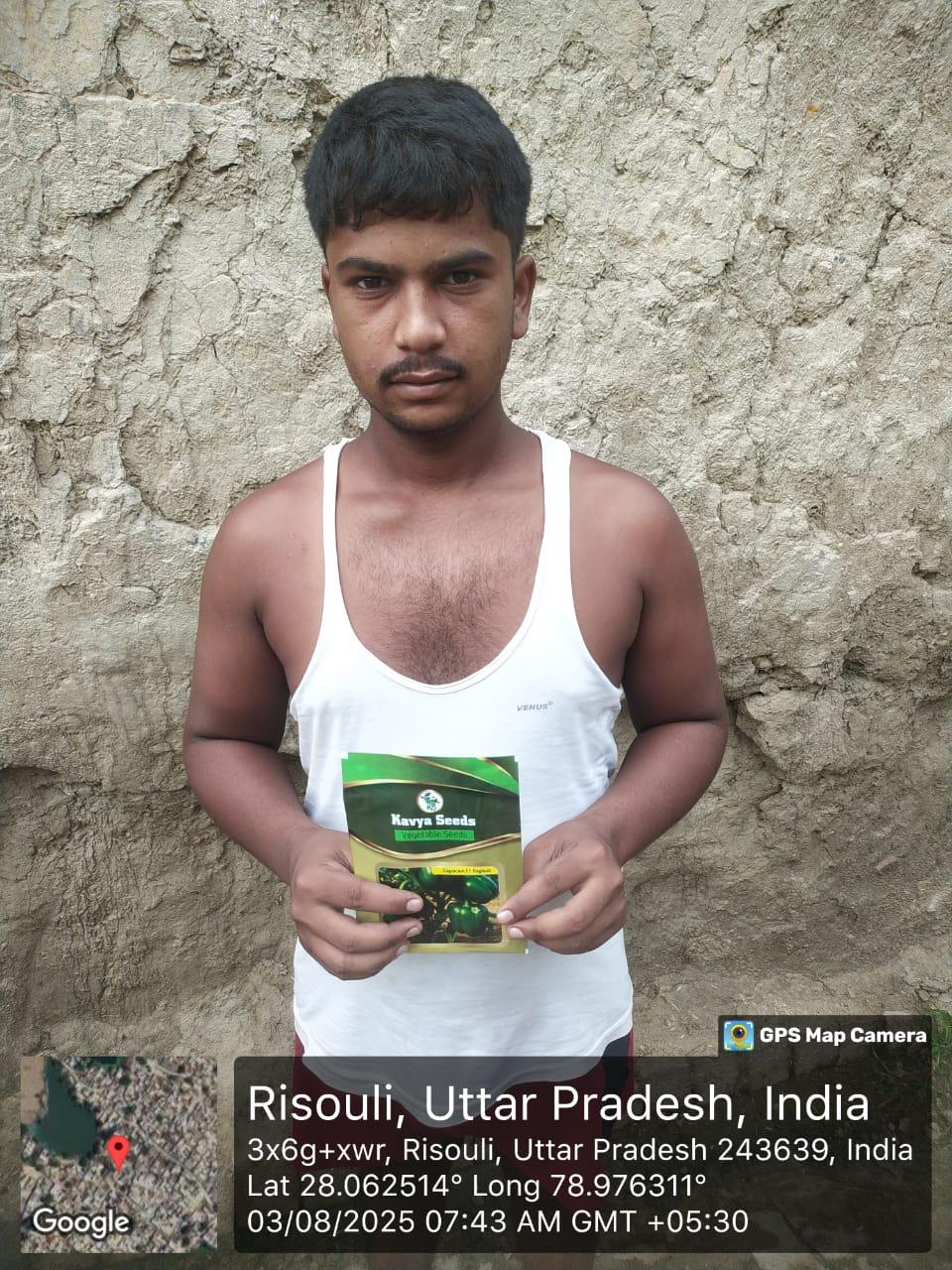 A farmer in Risouli, Uttar Pradesh, holding a packet of Kavya Seeds vegetable seeds for agriculture.