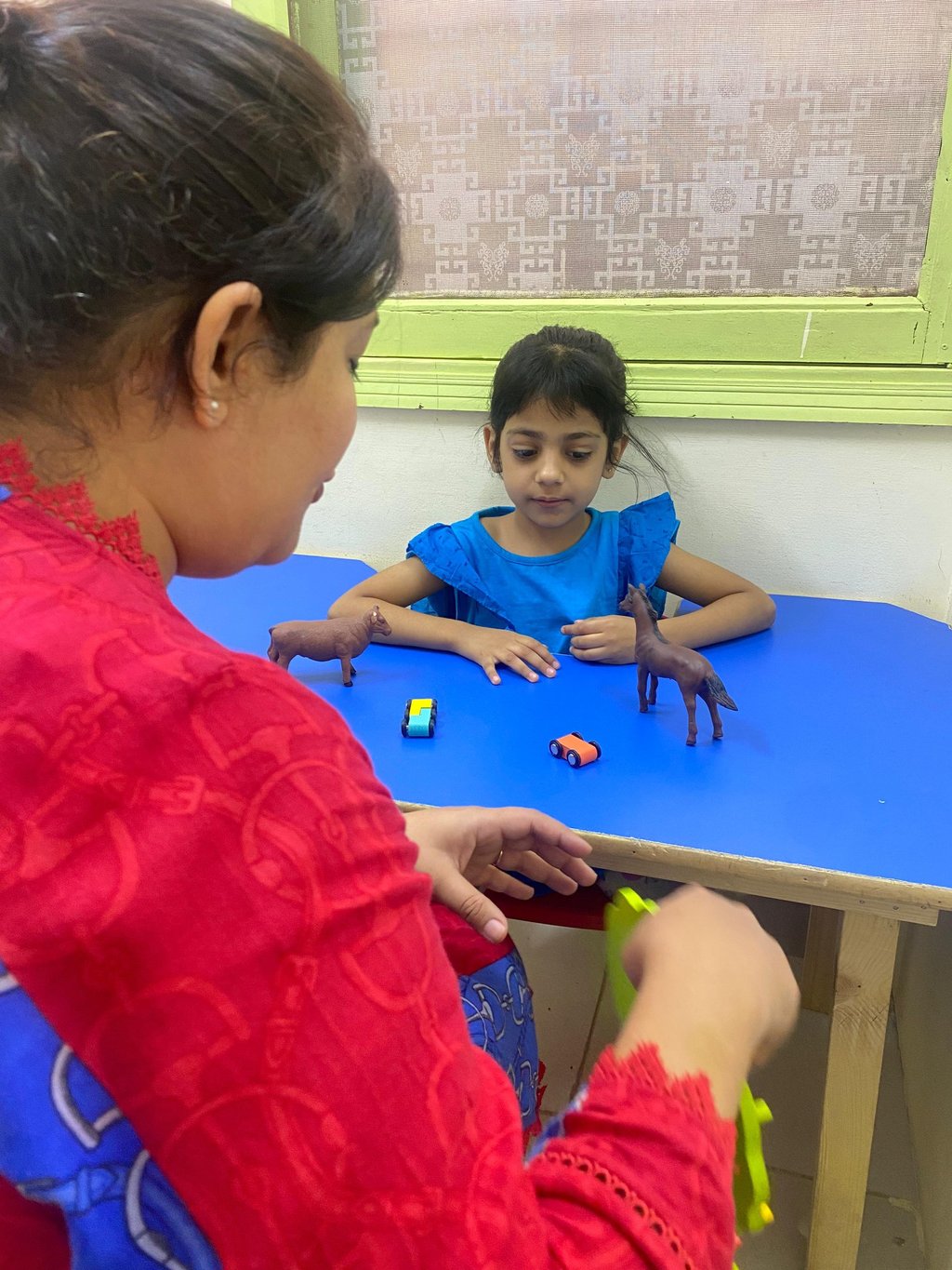 Child interacting with colorful therapy materials