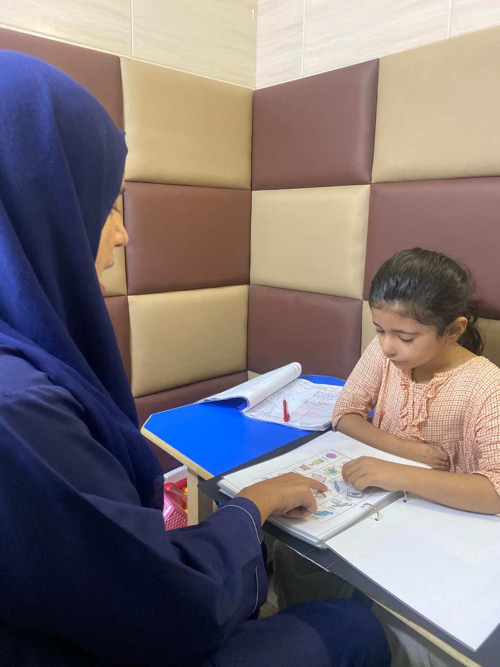 Therapist guiding young girl during session
