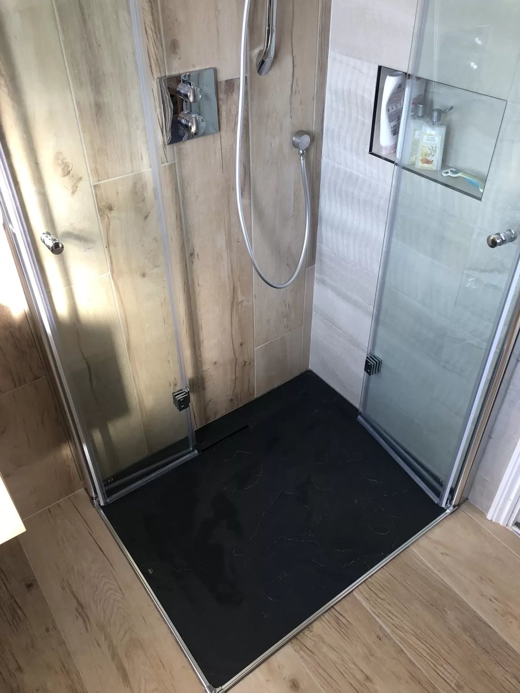 Newly installed walk-in shower with glass doors and tiled walls in Brighton bathroom remodel.