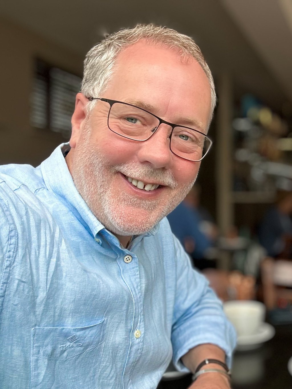 photograph of Rupert Kirby, photographer. Casual blue shirt, glasses and very handsom