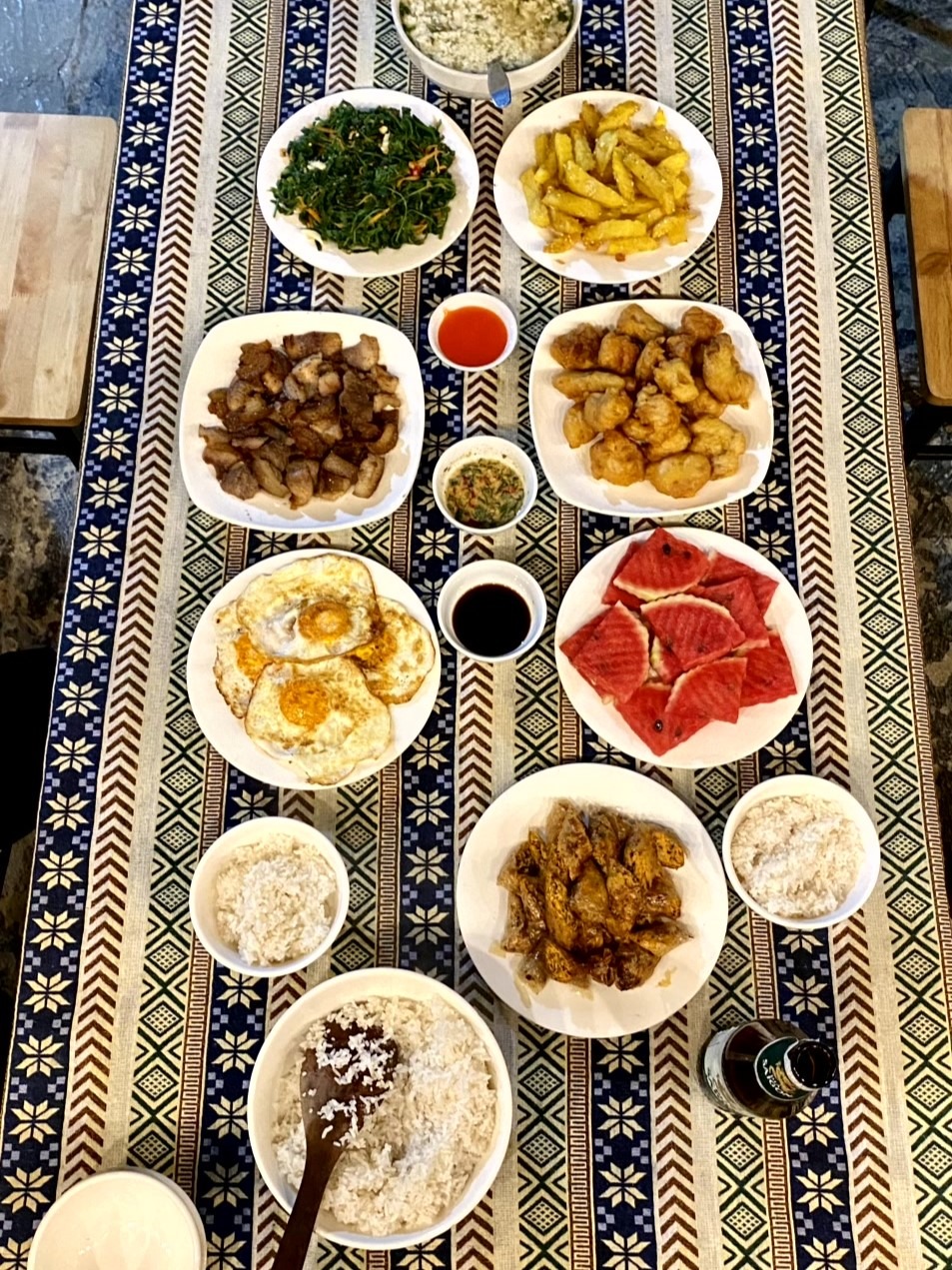 a table with plates of food and a bowl of rice