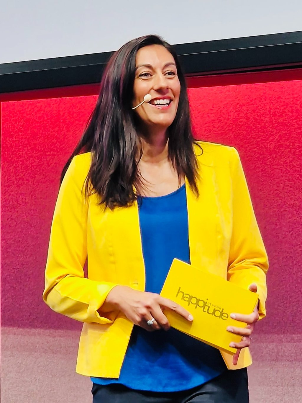 Aurelie Litynski speaking on stage about positive workplace culture