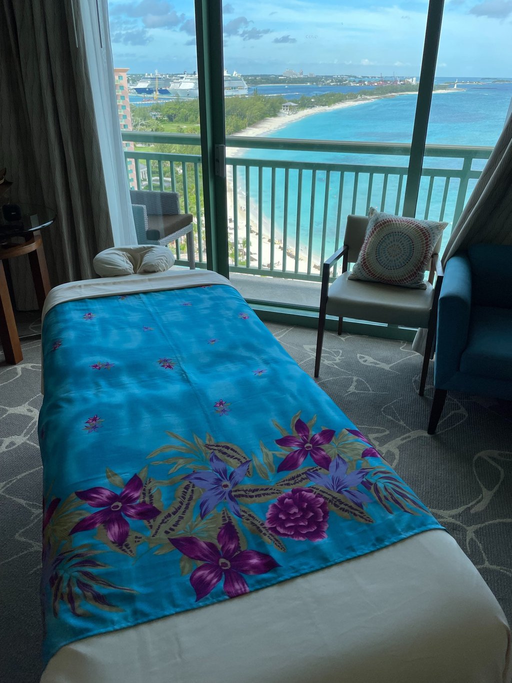a hotel room with a view of the ocean and a massages by sophia massage table