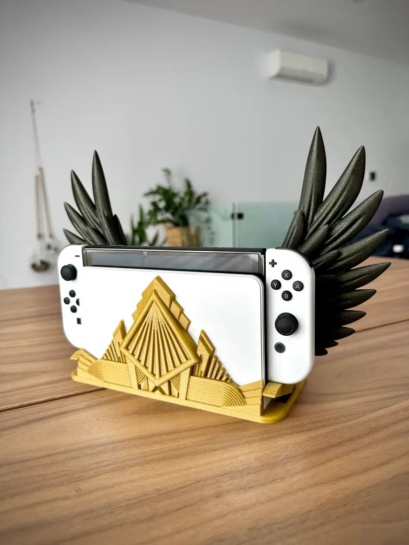 Custom 3D printed gold and black winged Nintendo Switch dock on a wooden table.