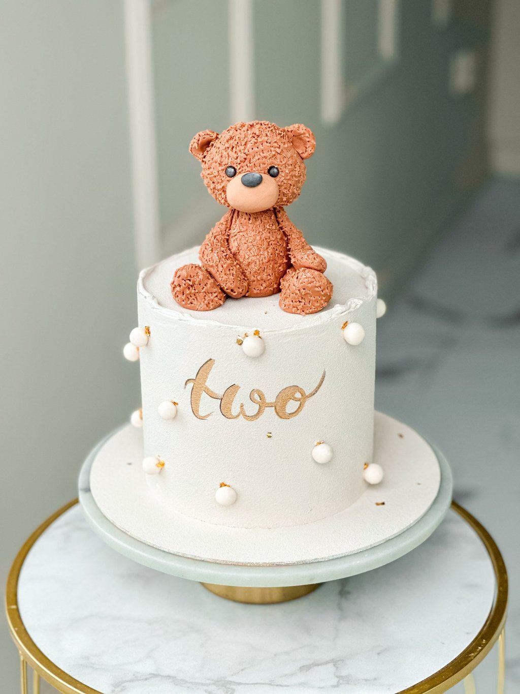 a teddy bear sitting on top of a cake