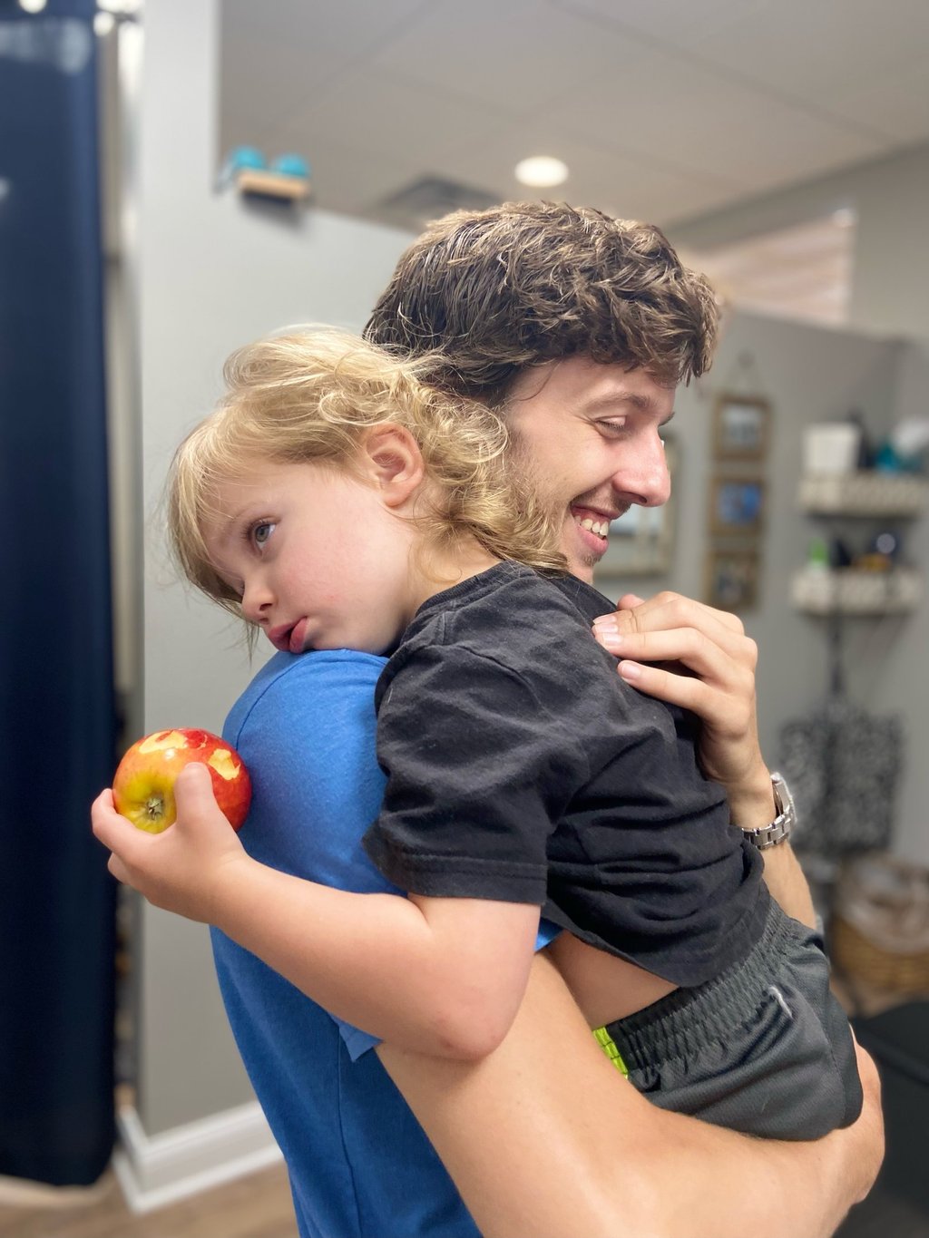 Child rests on Franklin Chiropractor's shoulder during adjustment to help him calm and rest