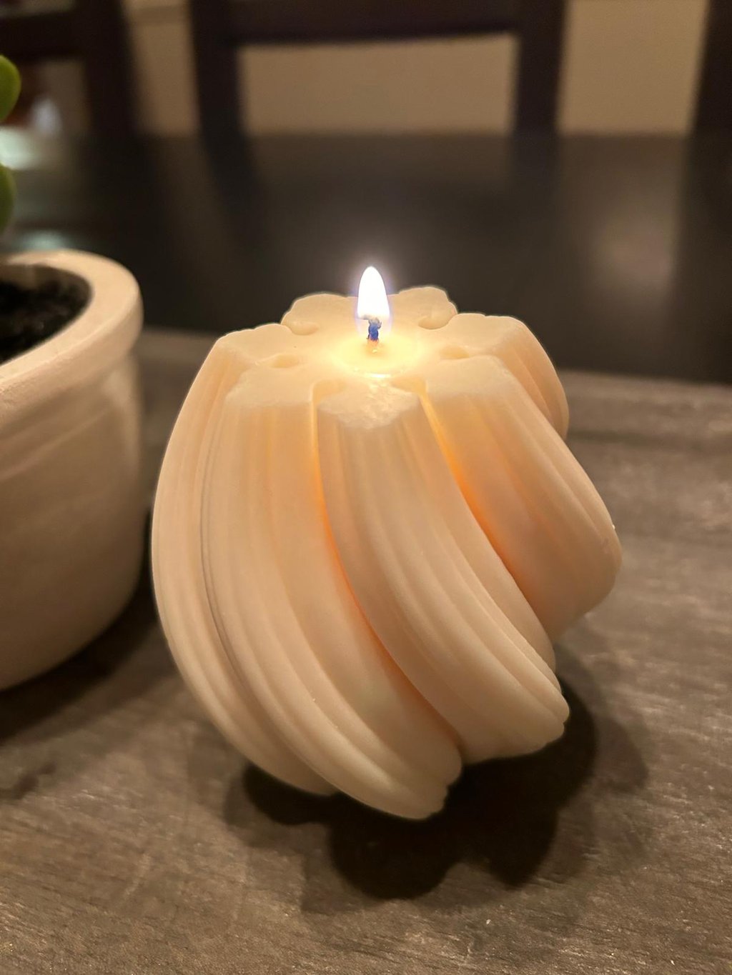 White twisted candles lit over a grey board