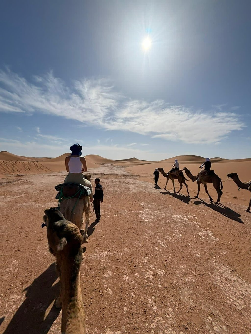 Group of travellers on camel trek in the Moroccan Sahara desert