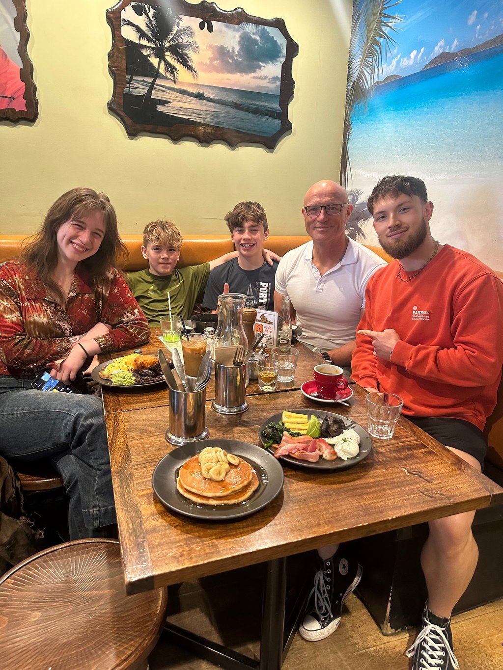 Shaun enjoying brunch with his children at a tropical-themed cafe.